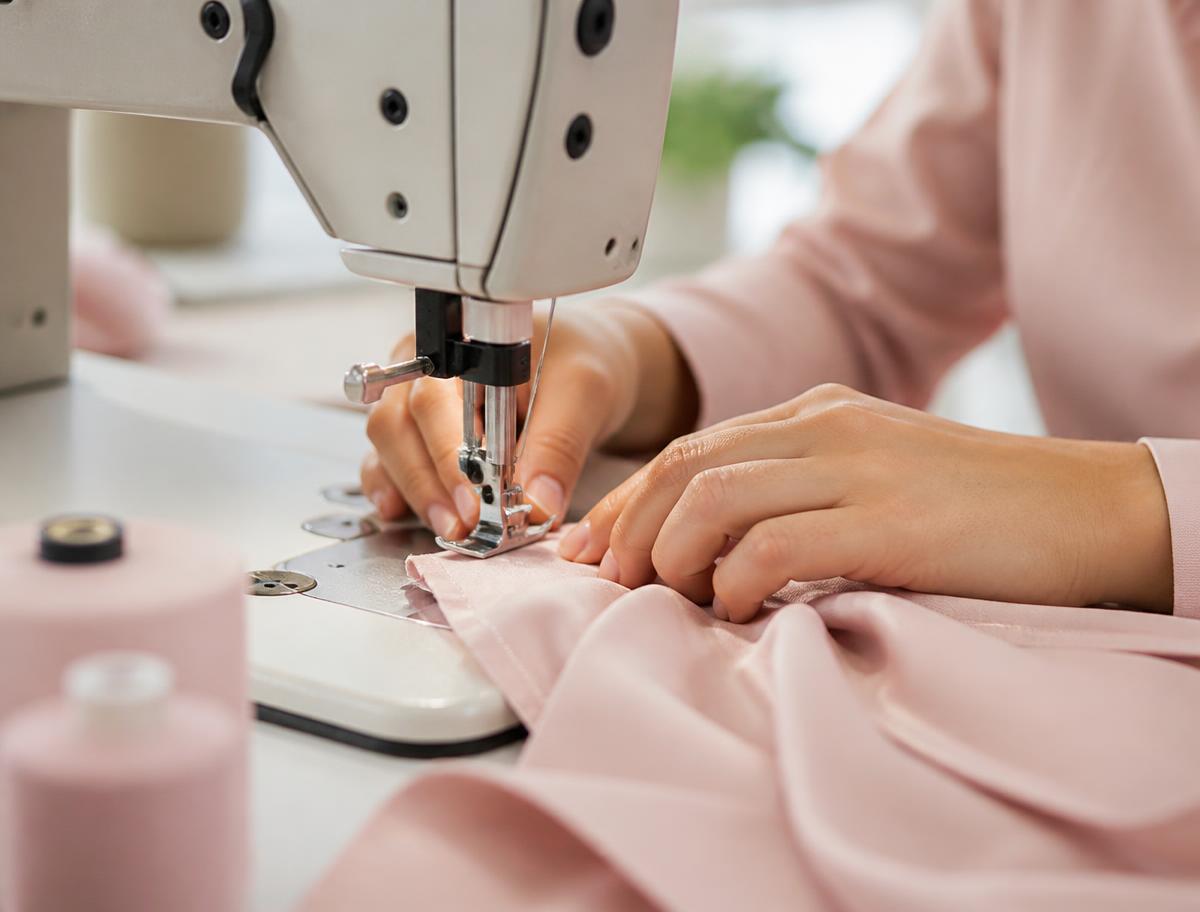 Vakkundig naaiwerk aan een kledingstuk op een professionele naaimachine